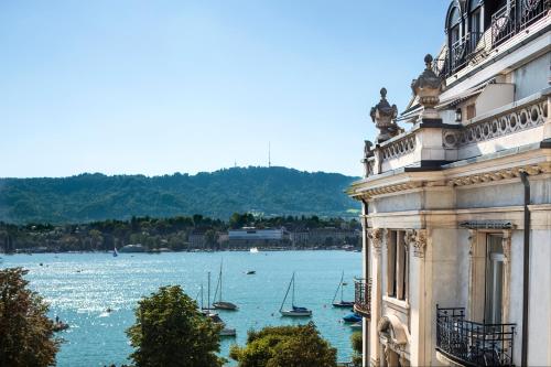 a building with a view of a body of water with boats at La Réserve Eden au Lac Zurich in Zurich