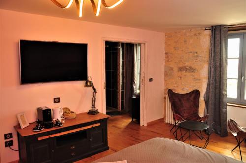 a living room with a flat screen tv on a wall at L'Esprit du Causse in Concots