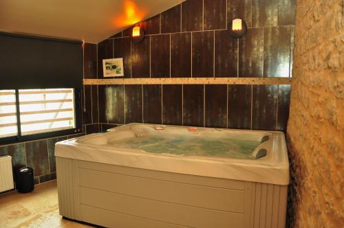 a large bath tub in a bathroom with wooden walls at L'Esprit du Causse in Concots