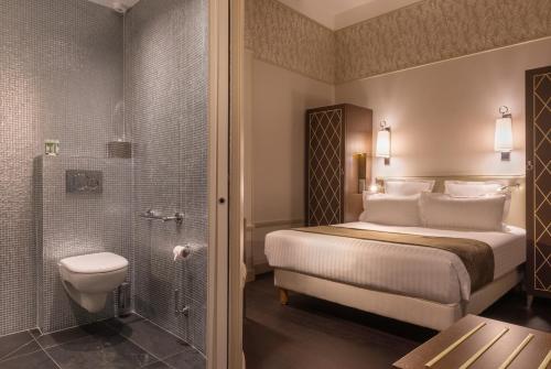 una camera d'albergo con letto e doccia di Crystal Hotel a Parigi