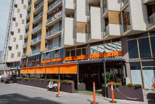a large apartment building with an orange sign on it at Aparthotel Tangerine in Batumi