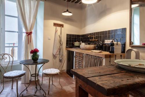 kuchnia ze stołem i stołkami w pokoju w obiekcie Gris Piedra Home w mieście Lourmarin