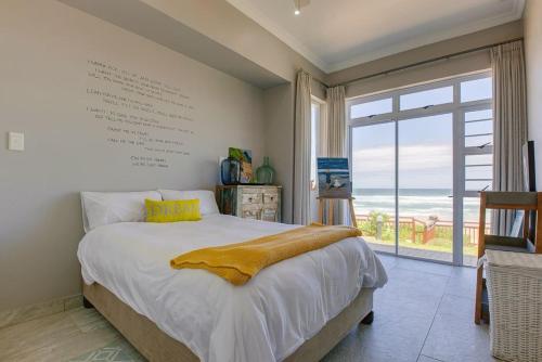 1 dormitorio con cama grande y ventana grande en Shanalulu Sands - full inverter, en Wilderness