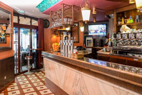 un bar dans un restaurant avec une télévision et un comptoir dans l'établissement HOTEL HOVI DE LA MAIRIE, à Aubervilliers