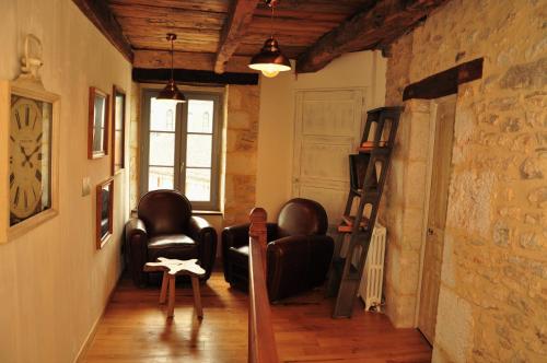 a living room with leather chairs and a brick wall at L'Esprit du Causse in Concots
