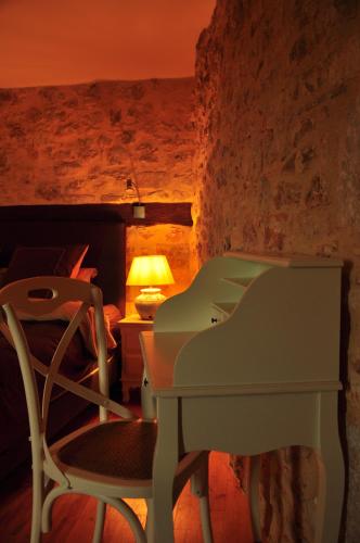a desk and a chair in a room with a lamp at L'Esprit du Causse in Concots
