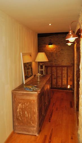 a room with a table with a lamp on a wooden floor at L'Esprit du Causse in Concots