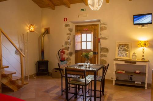 a room with a table with chairs and a television at Quinta do Tempo Turismo Rural in Monchique