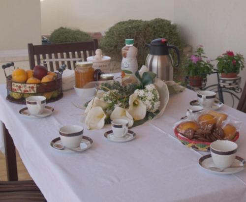 un tavolo con tazze e una ciotola di frutta e verdura di Villa Genny ad Altamura