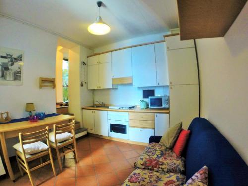a living room with a couch and a kitchen at Cozy Garden Retrait in Varenna