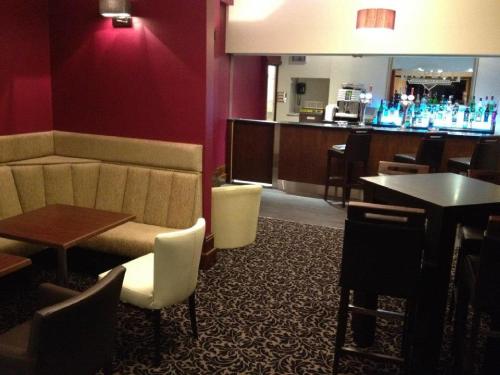 a restaurant with a bar with tables and chairs at Best Western Lancaster Morecambe Lothersdale Hotel in Morecambe