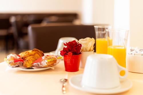 a table topped with a plate of food and orange juice at Le Val D'or & Le Theatre in Suresnes