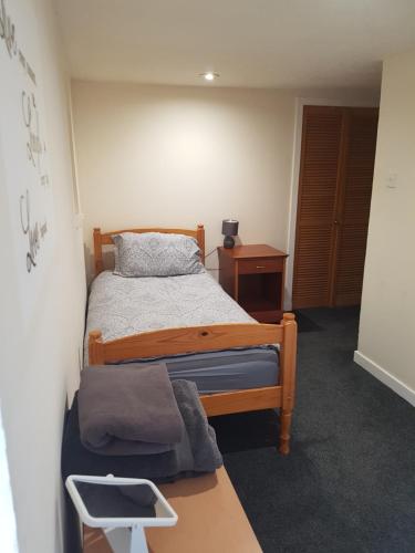 a small bedroom with a bed and a table at ladyhill flat in Elgin