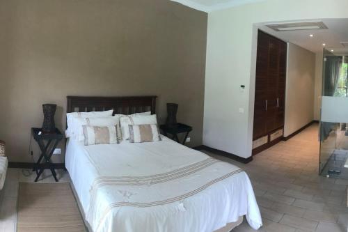 a bedroom with a large bed with white sheets and pillows at Eden Island Gem in Eden Island