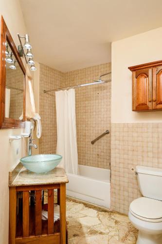 a bathroom with a sink and a toilet and a tub at Rondel Village in Negril