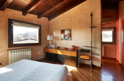 a bedroom with a bed and a desk and a window at Casa Vacanza Fontana Del Delfino in Bergamo