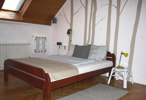 a bed in a room with trees on the wall at Fedra Apartment in Zrenjanin