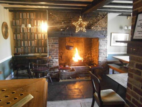 a living room with a fireplace and a table and chairs at The Barleycorn Inn in Collingbourne Ducis
