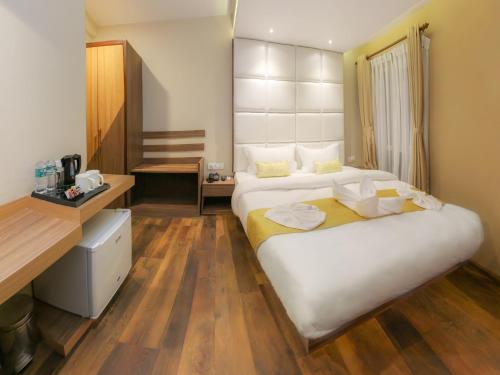 a hotel room with two beds and a desk at Hotel Bihani in Kathmandu