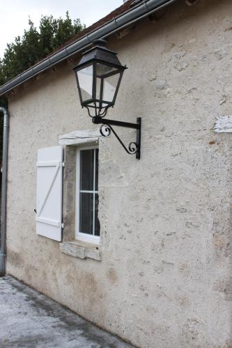 a light on the side of a building with a window at Domaine de Praline l'ensemble in Villerbon