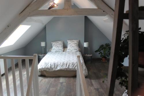 a bedroom with a bed in a attic at Domaine de Praline l'ensemble in Villerbon