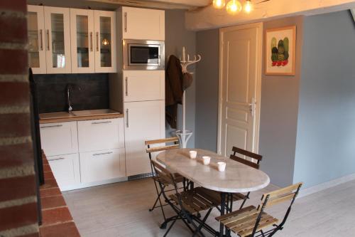 a kitchen and dining room with a table and chairs at Domaine de Praline l'ensemble in Villerbon