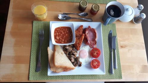a plate of breakfast food with beans beans and toast at Swanage Haven Boutique Guest House in Swanage
