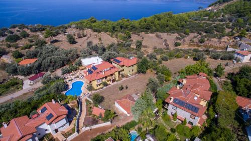 an aerial view of a house on a hill next to the water at Mandarin & Mango Boutique Hotel in Faralya