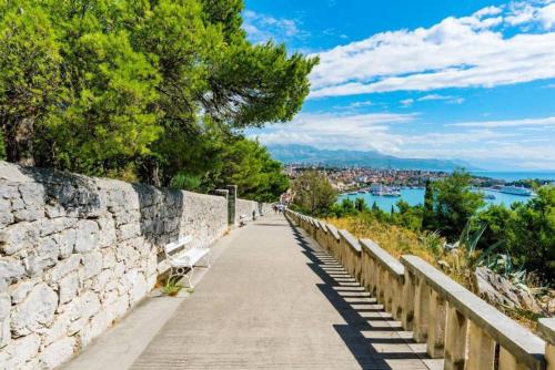 a walkway next to a stone wall and a river at Diocletian Studio Apartments in Split