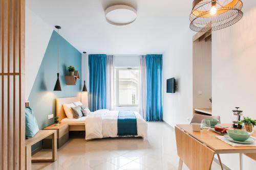 ein Schlafzimmer mit einem Bett mit blauen Vorhängen und einem Tisch in der Unterkunft Dynasta Central Suites in Athen