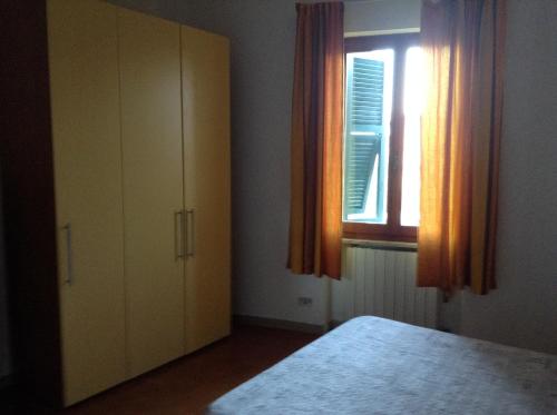 una camera con letto e finestra con tende arancioni di Ca' Mari ad Ameglia