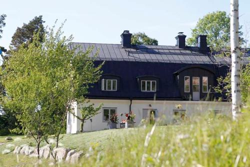 a large blue and white house on a field at Fredriksborg Hotell & Restaurang in Värmdö