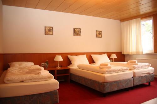 a room with two beds with towels on them at Hotel Garni Kaiserpfalz in Goslar