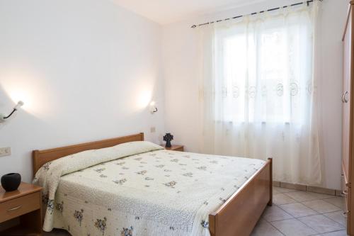 a bedroom with a bed and a window at Happy Days in Capo Vaticano