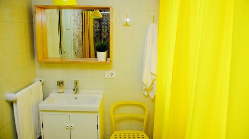 a yellow bathroom with a sink and a mirror at Ideas Peregrinas in Tui