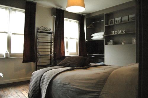 um quarto com uma cama num quarto com janelas em B&B Family@home66 em Bruges