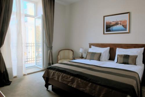 a bedroom with a large bed and a large window at Hotel Stara Lika in Gospić