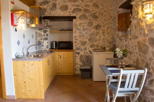 a kitchen with a sink and a table with chairs at Quinta do Tempo Turismo Rural in Monchique