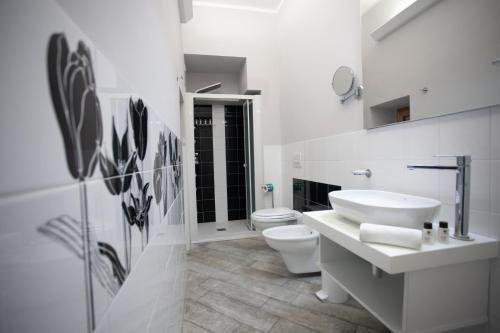 a white bathroom with a sink and a toilet at Le Due Sicilie in Tropea