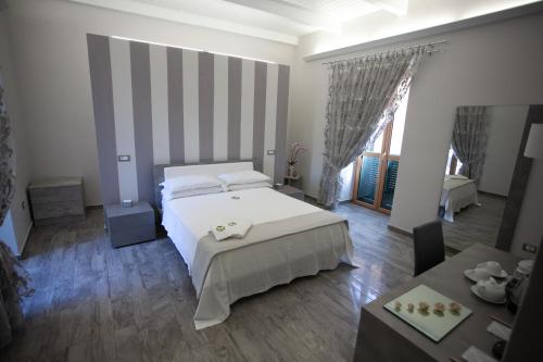 a bedroom with a large white bed and a table at Le Due Sicilie in Tropea