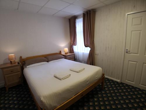 a bedroom with a bed with two towels on it at The Hopton Hotel in Blackpool