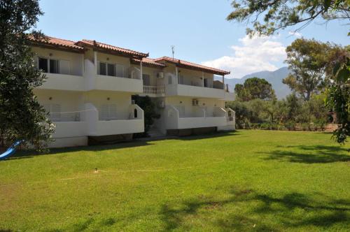 - un grand bâtiment avec une grande cour devant dans l'établissement Sani Kasimis, à Kyparissia