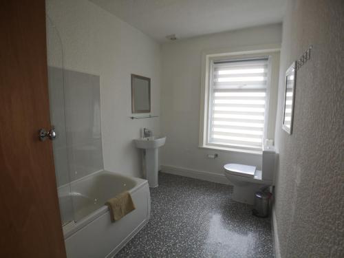 a bathroom with a tub and a toilet and a sink at The Hopton Hotel in Blackpool