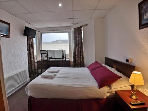 a bedroom with a large bed with a large window at The Hopton Hotel in Blackpool