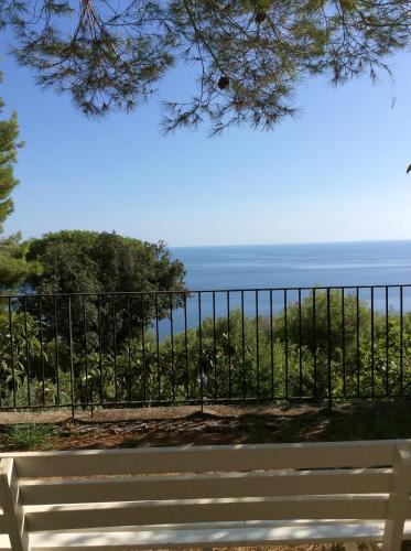 a bench in front of a fence with the ocean at Il Casalino in Maratea