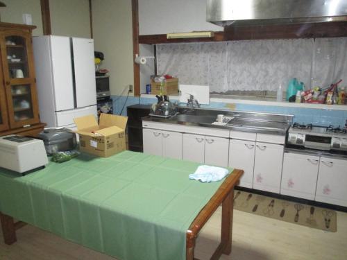 een keuken met een tafel met een groen aanrecht bij Minpaku TOMO 8 tatami room / Vacation STAY 3707 in Hida