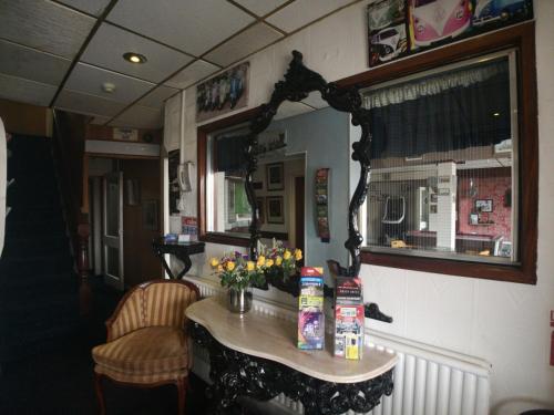 a room with a mirror and a table with flowers at The Hopton Hotel in Blackpool