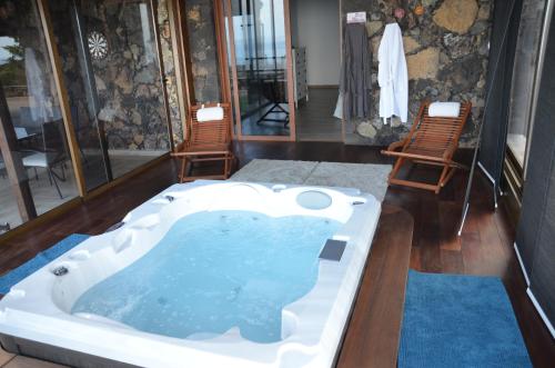 uma banheira de hidromassagem num quarto com duas cadeiras em Villa Tejeguate em Frontera