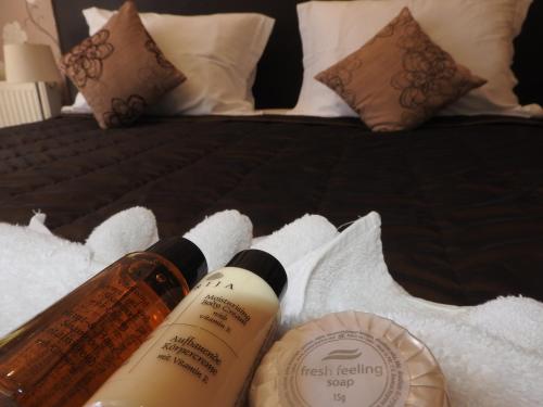 two bottles of treatment healing on a bed with towels at Hill View Hotel Apartments in Pissouri