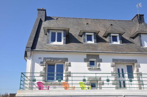 een huis met stoelen op een balkon bij Chez Tib in Trégunc